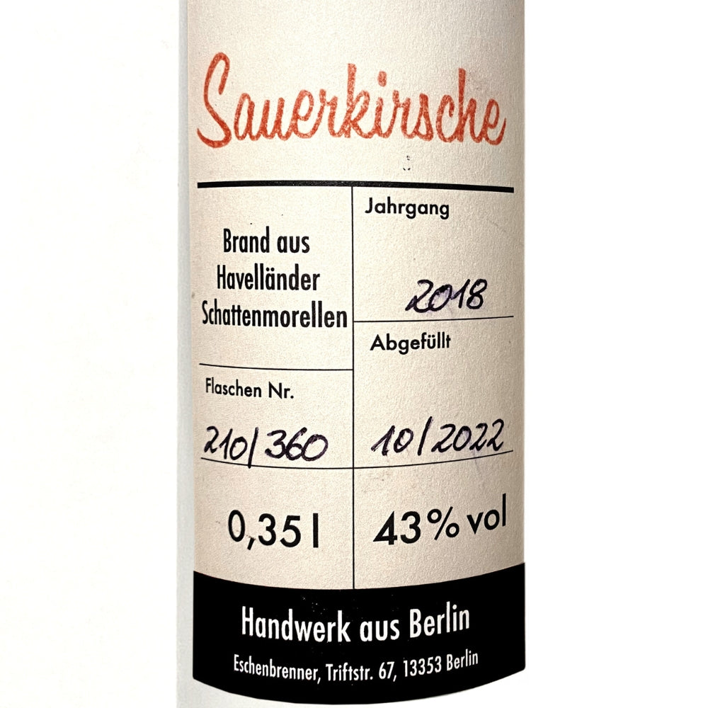 Detailaufnahme des Etiketts vom Eschenbrenner Sauerkirschbrand, Jahrgang 2018, abgefüllt 10/2022, 43 % vol, handgefertigt in Berlin.