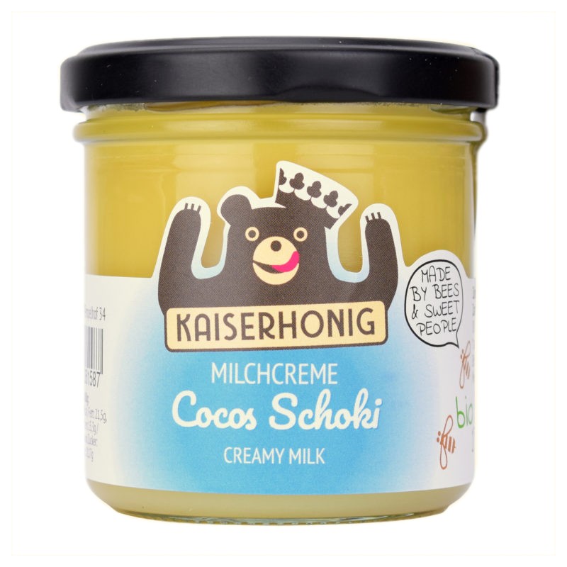 Gelbes Glas Kaiserhonig Milchcreme Cocos Schoki mit schwarzem Deckel, fröhliches Bärenlogo mit Krone und blauer Etikettenfarbe, Aufschrift „Made by Bees & Sweet People“.