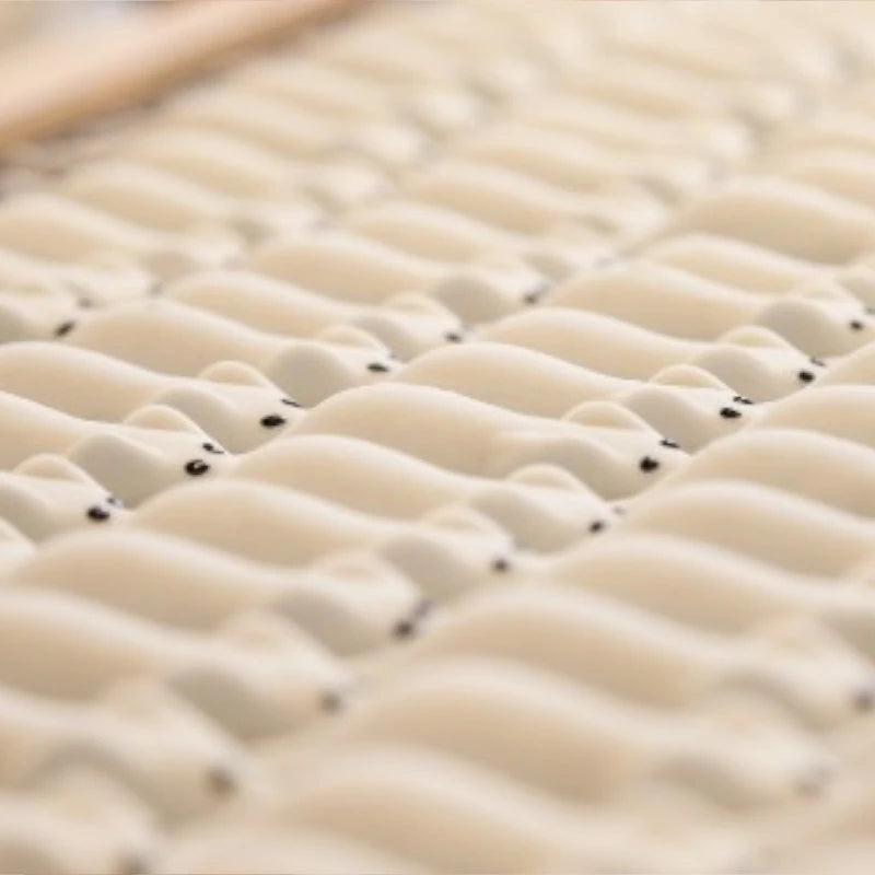 Weiße Schaumzuckermäuse mit schwarzen Augen, ordentlich in Reihen auf einem Blech angeordnet.