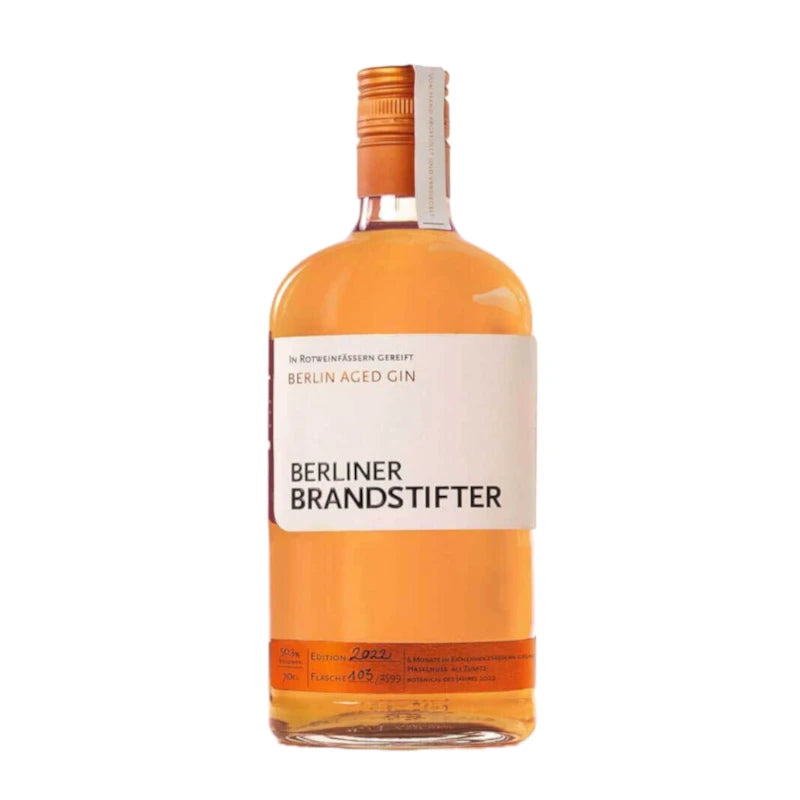 Flasche Berliner Brandstifter Berlin Aged Gin mit weißem Etikett und orangefarbenem Inhalt, stehend vor weißem Hintergrund