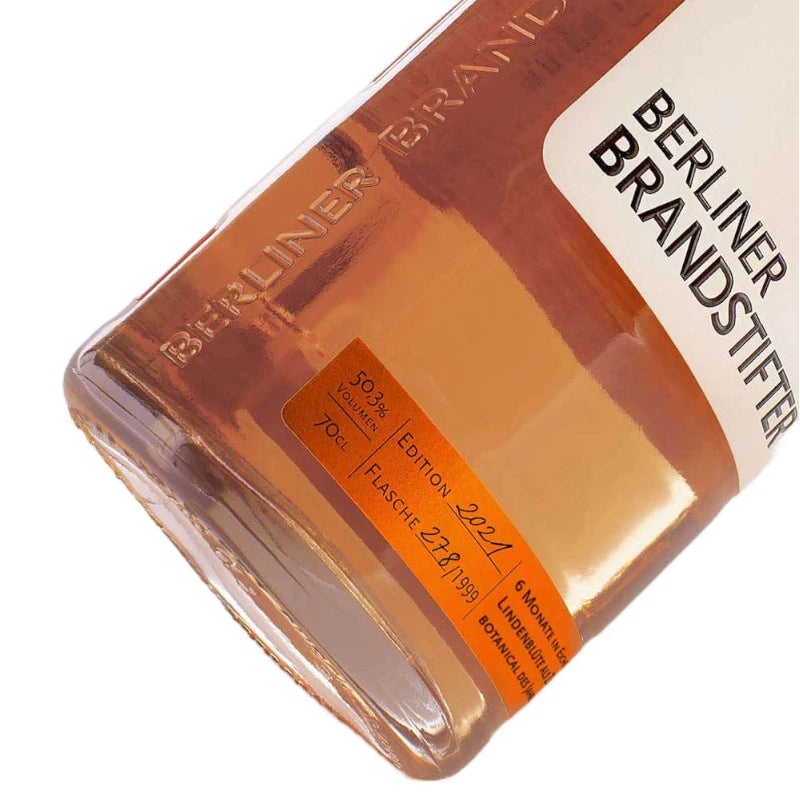 Nahaufnahme der Berliner Brandstifter Flasche mit Fokus auf die geprägte Glasstruktur und das orangene Etikett mit Jahrgangsangabe