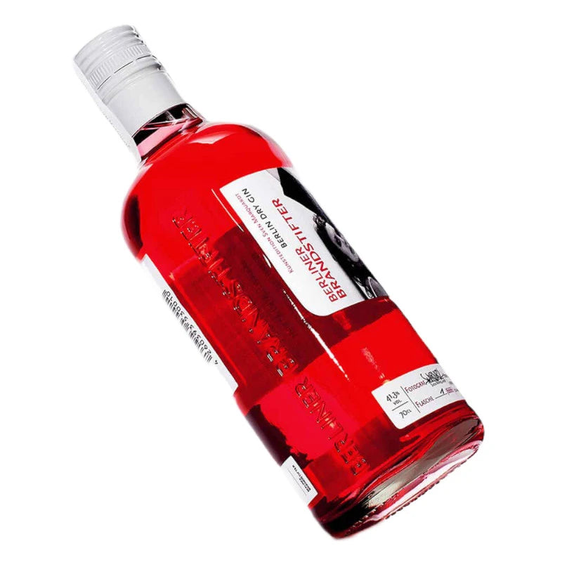 Schräg gelegte Flasche des Berliner Brandstifter Berlin Dry Gin in Kunstedition mit rotem Inhalt und Fotolabel