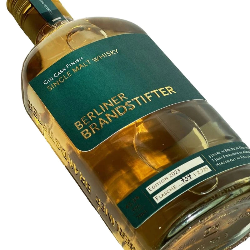 Detailaufnahme der liegenden Whiskyflasche mit Fokus auf die goldene PrĂ€gung von âBerliner Brandstifterâ und der individuellen Flaschennummer auf dem unteren Etikett.