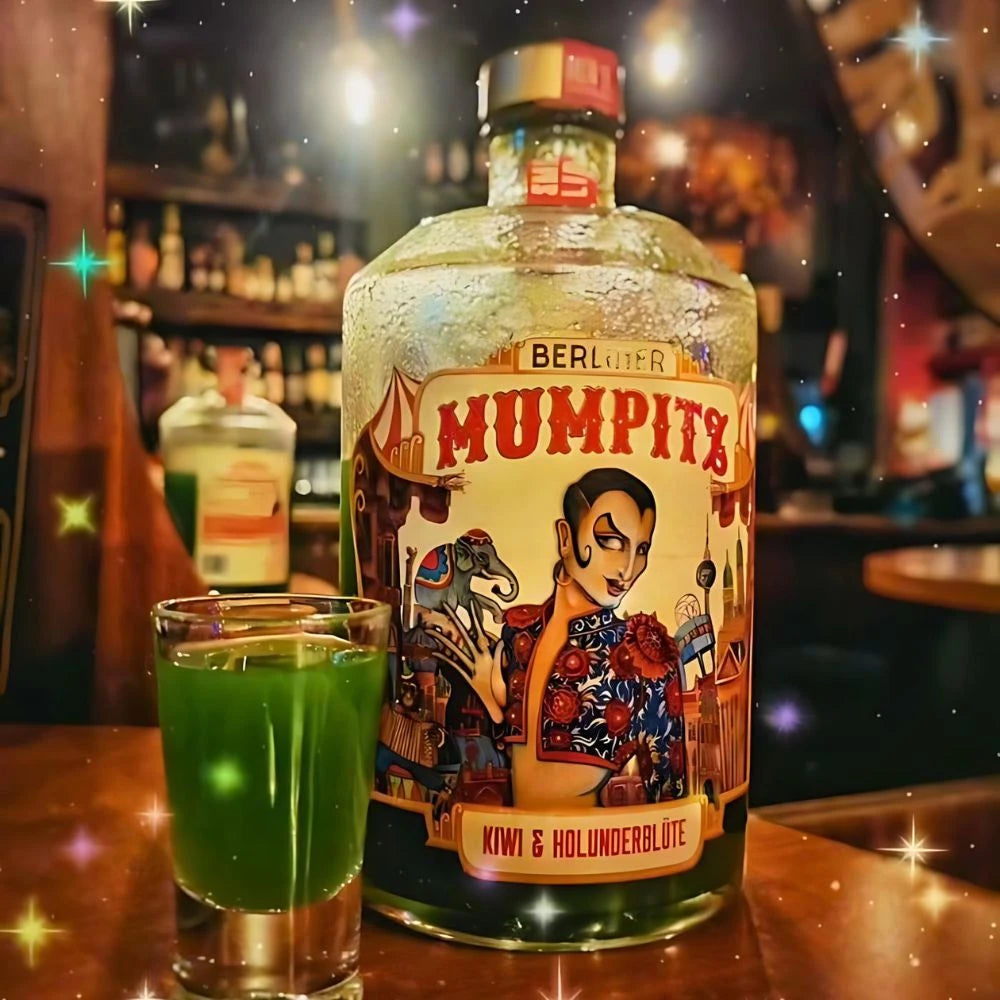 Berliner Mumpitz Kiwi & Holunderblüte Likör eisgekühlt in einer Bar, mit passendem grünen Shot-Glas im Vordergrund und glitzerndem Lichtspiel im Hintergrund.
