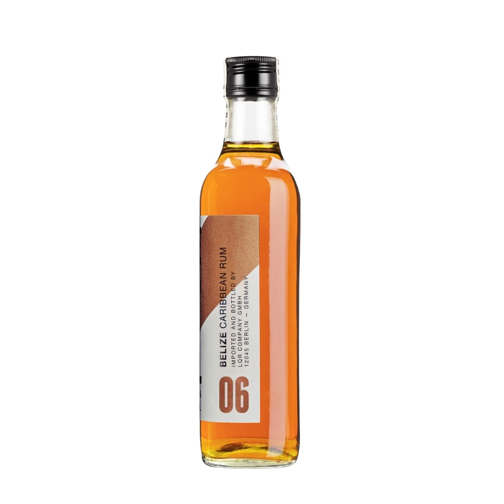 CUATE Rum 06 Añejo Reserva – Seitenansicht der 700 ml Flasche mit orange-braunem Etikett und der Aufschrift „Belize Caribbean Rum“.