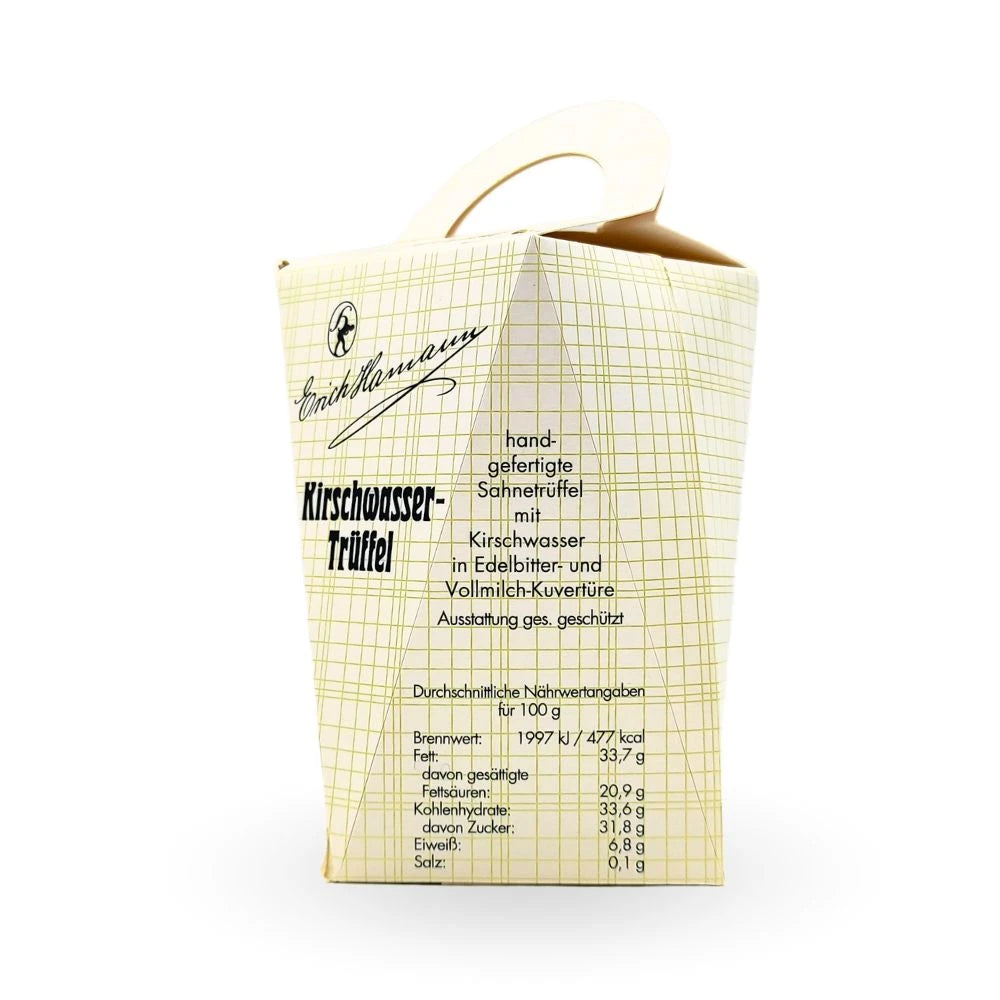 Rückseite der Geschenkschachtel von Erich Hamann. Text: „Handgefertigte Sahnetrüffel mit Kirschwasser in Edelbitter- und Vollmilch-Kuvertüre“. Darunter Nährwertangaben pro 100 g und klassisches Karomuster auf cremefarbener Oberfläche.