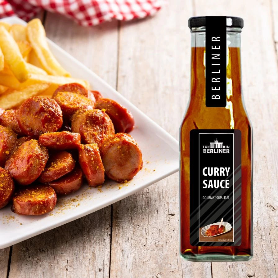 Currywurst mit Pommes auf weißem Teller, daneben ICK BIN BERLINER Curry Sauce in Flasche – klassische Berliner Kombination mit hausgemachter Sauce.