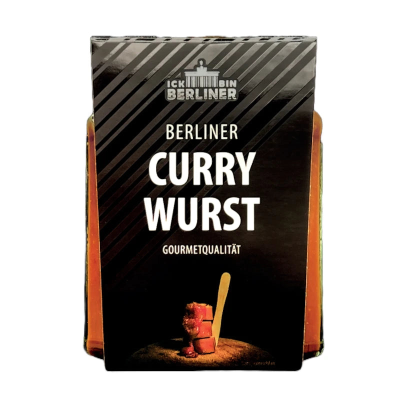 Vorderansicht eines Glases Berliner Currywurst in Gourmetqualität mit schwarzer Verpackung und weißer Aufschrift „ICK BIN BERLINER – Berliner Currywurst – Gourmetqualität“, darunter ein Symbolbild mit Currywurststücken auf Holzbrett.