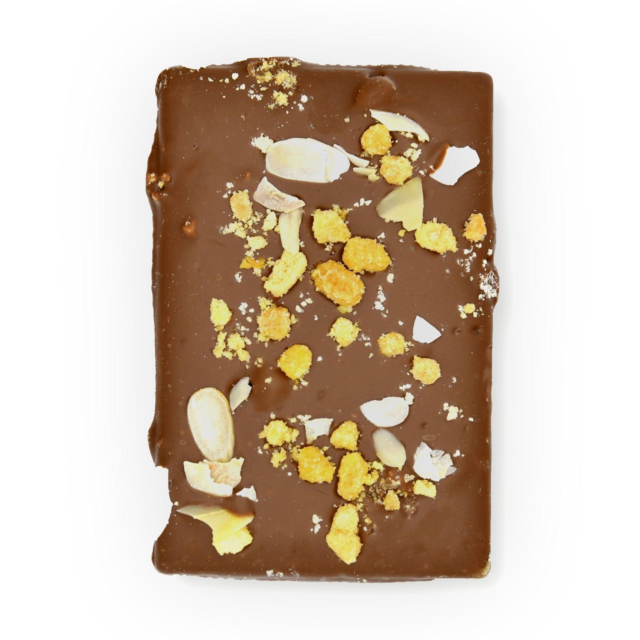 Obenansicht einer Vollmilch-Schokoladentafel mit Streuseltopping und Mandelblättchen – Berliner Handarbeit mit Geschmack und Stil.