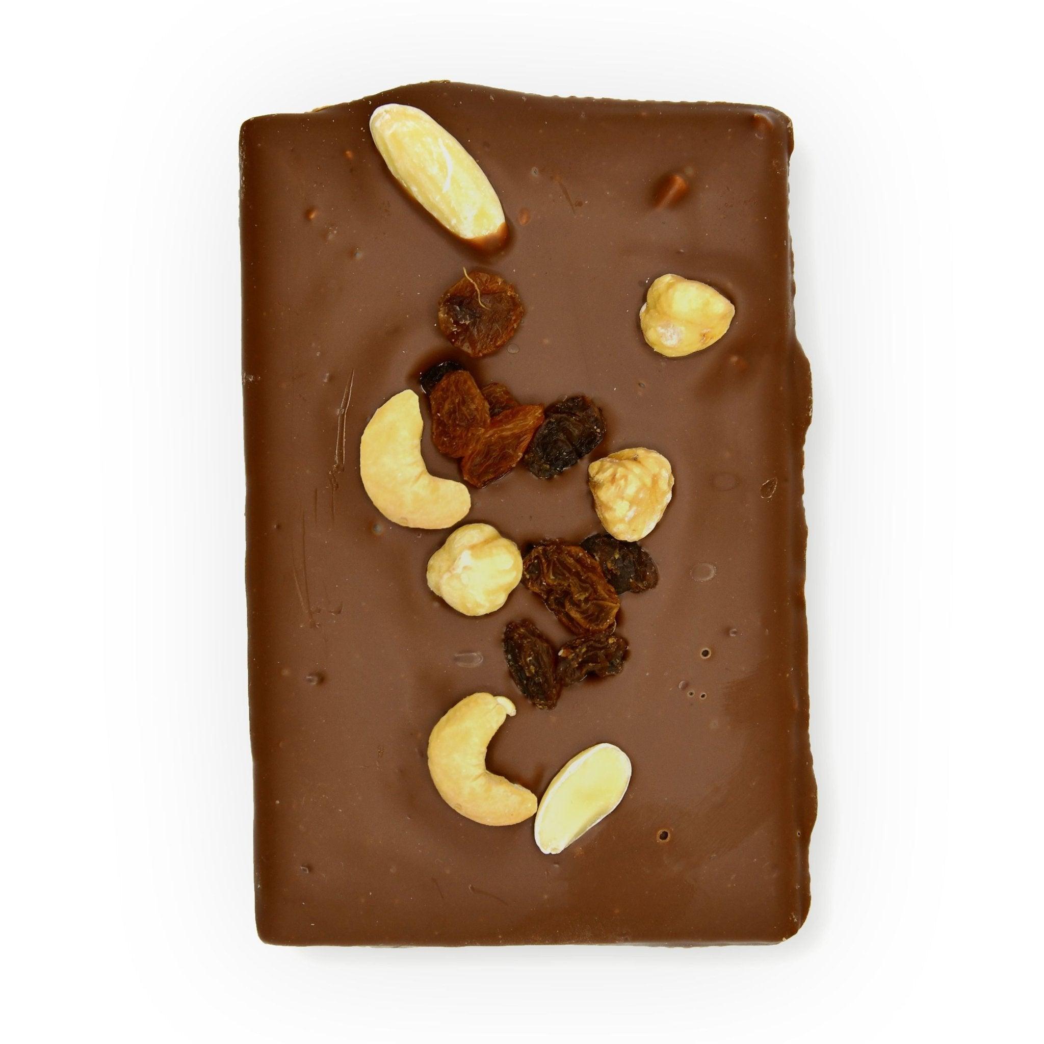 Obenansicht der Vollmilchschokolade mit knackigen Haselnüssen, Cashews und saftigen Rosinen – Berliner Handarbeit auf den Punkt.