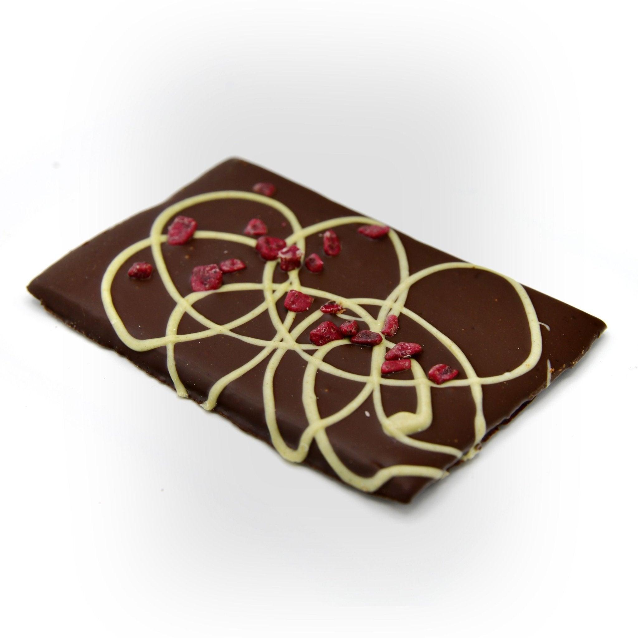 Feinste Zartbitterschokolade mit Kirsche und Minze, diagonal aufgenommen – ein Berliner Manufakturprodukt für Genießer mit Anspruch.