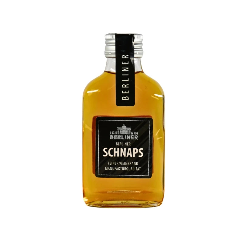 Kleine Flasche Berliner Schnaps mit goldfarbenem Weinbrand, schwarzes Etikett mit weißer Schrift und Manufakturhinweis in edlem Design.