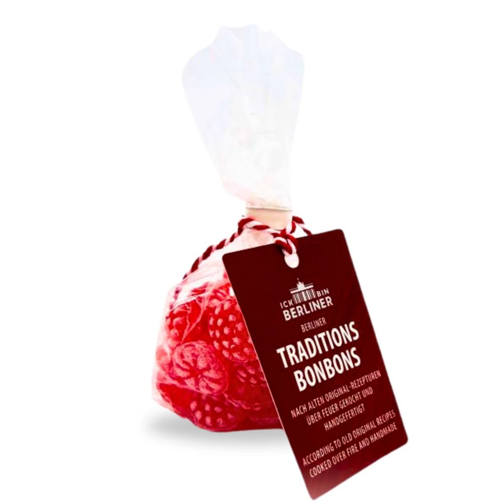 Transparenter Zellophanbeutel mit roten Himbeer-Bonbons der Marke Ick bin Berliner, verziert mit einem braun-roten Etikett, auf dem „Traditionsbonbons – nach alten Original-Rezepturen über Feuer gekocht und handgefertigt“ steht.