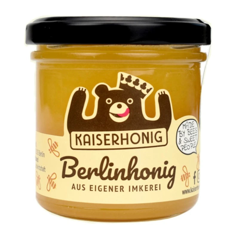 Honigglas mit schwarzem Deckel und Etikett der Marke Kaiserhonig, illustriert mit einem lachenden Bären mit Krone; Aufschrift „Berlinhonig – aus eigener Imkerei“, daneben der Hinweis „Made by bees & sweet people“.