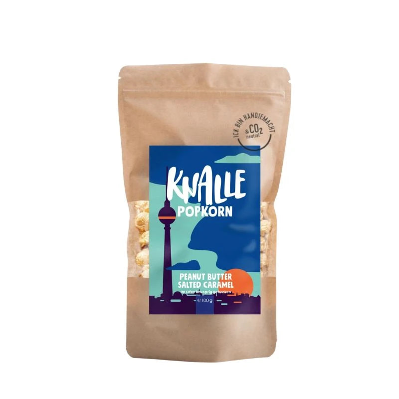 Knalle Popcorn Peanut Butter Salted Caramel, 100 g – brauner Standbeutel mit Berliner Skyline und Fernsehturm auf dem Etikett. Handgemacht in Berlin, CO₂-neutral gebacken.