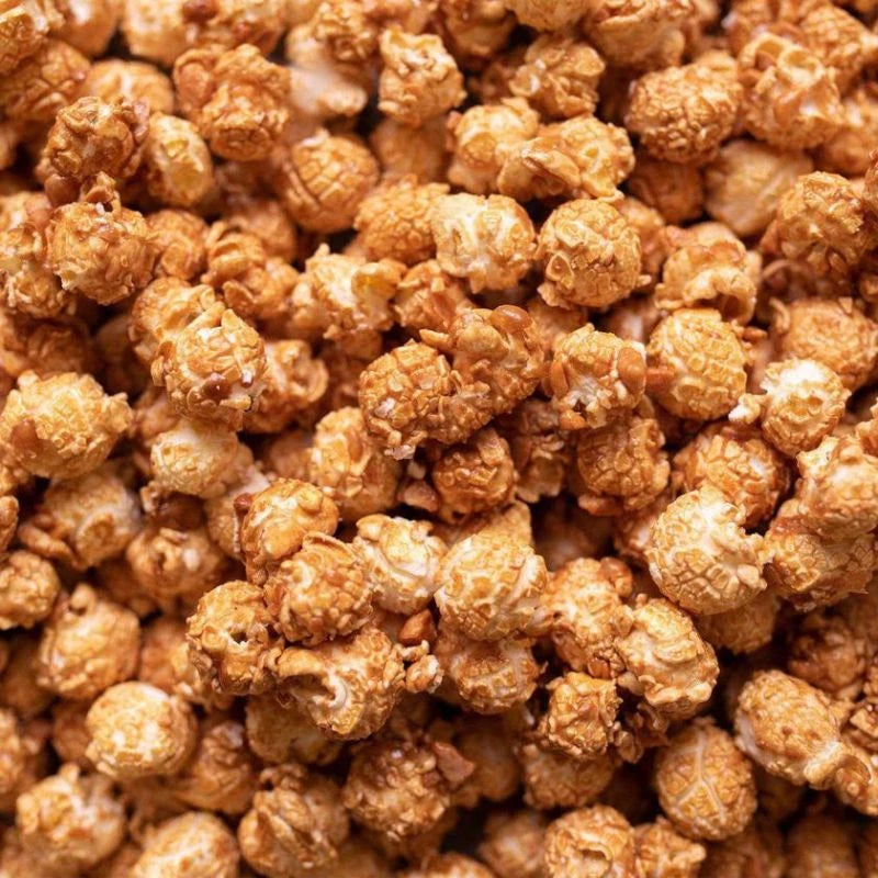 Detailansicht: Knalle Popcorn mit Erdnussstückchen und goldener Karamellglasur. Knusprig gebacken, intensiv im Geschmack – Berliner Popkornditorei in Perfektion.