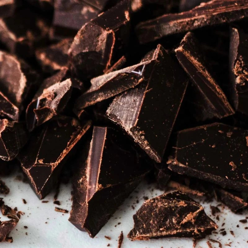 Nahaufnahme grob gebrochener Stücke dunkler Schokolade – hochwertige Zutat für das Berliner Manufakturpopcorn mit intensivem Kakaoaroma.