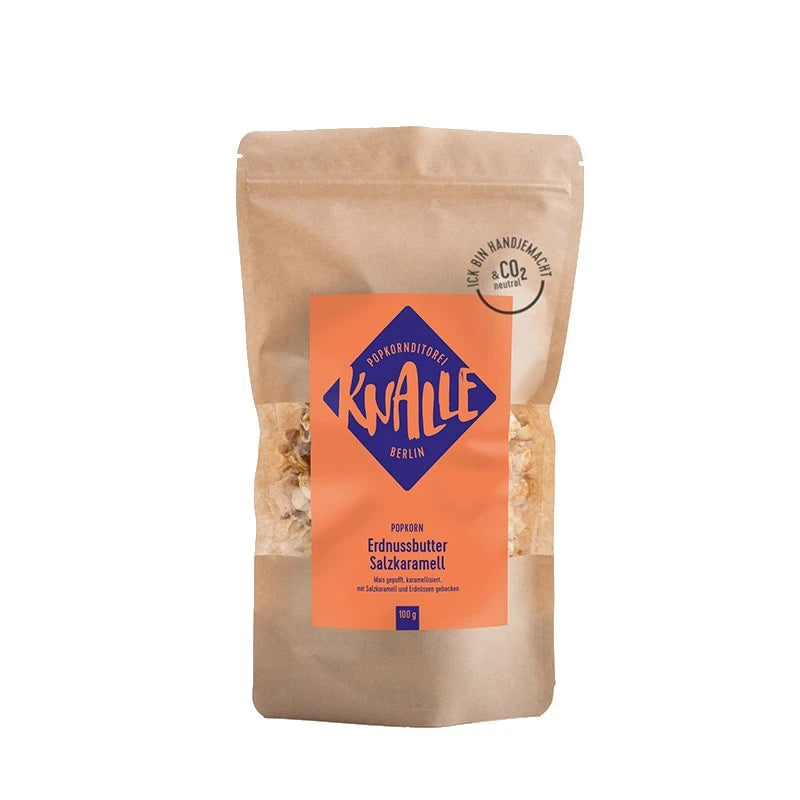 Knalle Popkorn Erdnussbutter Salzkaramell, 100 g im braunen Beutel mit orange-violettem Etikett. Berliner Manufakturprodukt – handgemacht, CO₂-neutral gebacken.