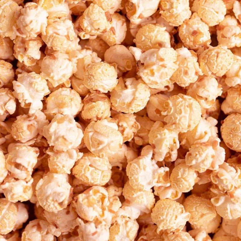 Detailansicht von karamellisiertem Popcorn mit Kokosflocken. Knusprig gebacken, mit Tonkabohne und Kokos verfeinert – vegane Manufakturqualität aus Berlin.