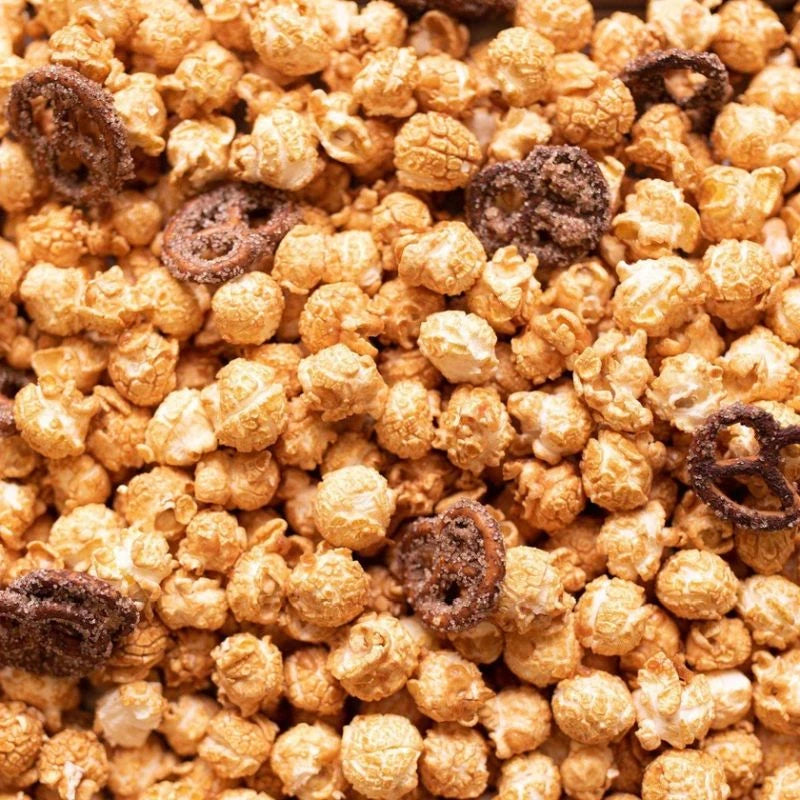 Detailaufnahme von karamellisiertem Popcorn mit Salzbrezeln und weißer Schokolade. Knuspriger Snack aus der Berliner Knalle Popkornditorei – süß-salzige Kombination mit feinem Crunch.