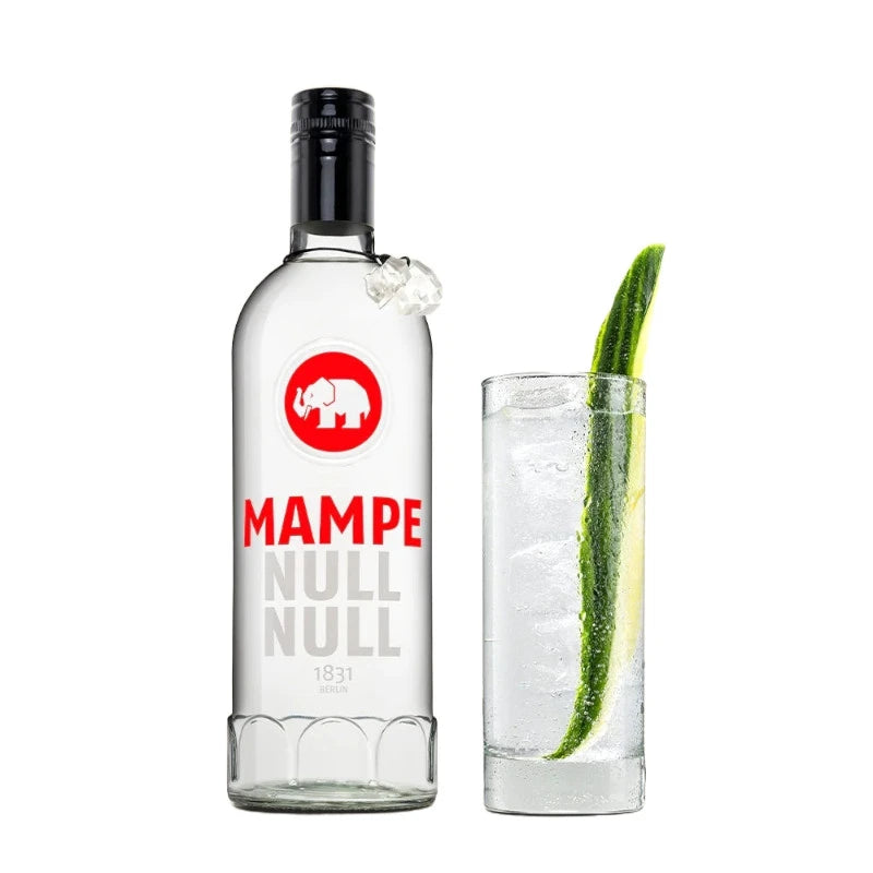 Mampe Null Null Flasche neben einem Longdrinkglas mit klarem alkoholfreiem Cocktail auf Eis, garniert mit Gurkenstreifen. Erfrischender Gin-Tonic-Style Drink ohne Alkohol.