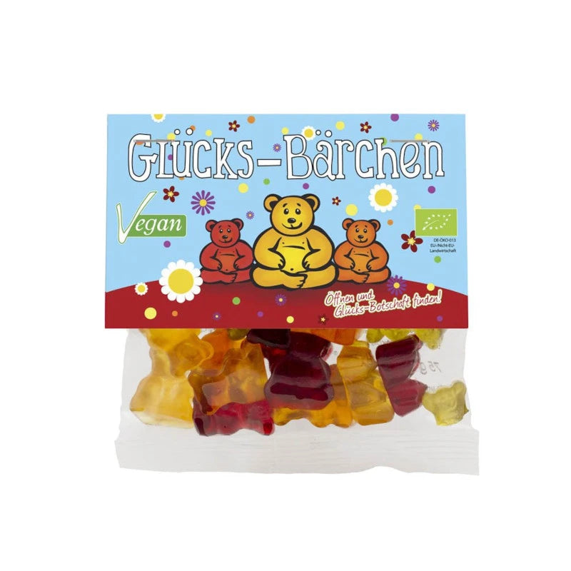 Mind Sweets Glücks-Bärchen – vegane Bio-Fruchtgummis im 50 g Beutel mit drei meditierenden Bären vor buntem Blumenhintergrund. Aufschrift: ‚Öffnen und Glücks-Botschaft finden!‘ – aus Berlin, mit Herz.