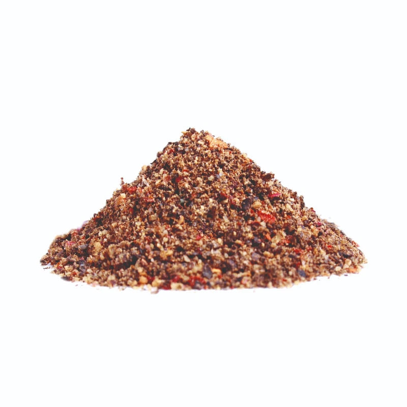 Fein gemahlene Pfeffermischung „Glorreiche Halunken“ als kleine Gewürzanhäufung auf weißem Untergrund, mit sichtbaren roten und dunklen Körnchen.