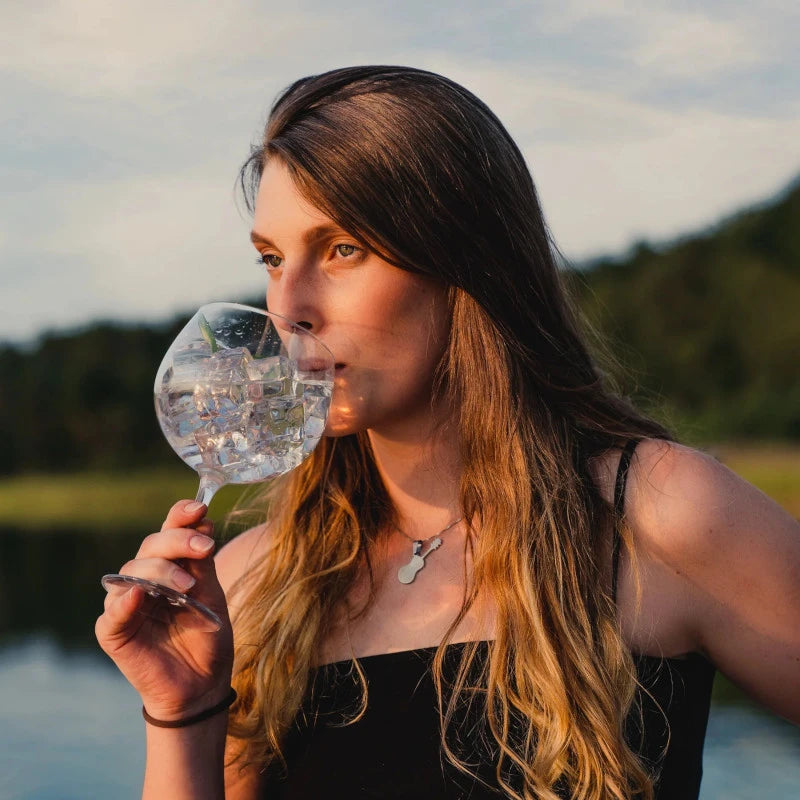Junge Frau genießt Spree Gin mit Eis und Gurke in der Natur – Berliner Genussmoment mit regionalem Dry Gin aus nachhaltiger Manufaktur.