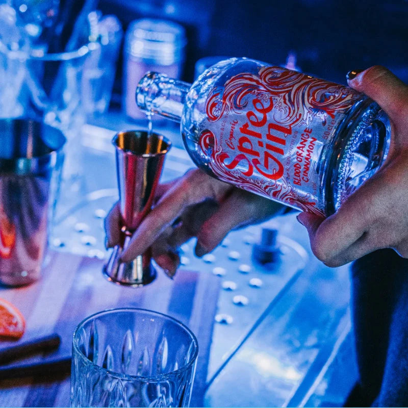 Bartender dosiert Spree Gin Blood Orange Cinnamon – handwerklich produzierter Berliner Bio-Gin für kreative Barkonzepte mit winterlicher Note.