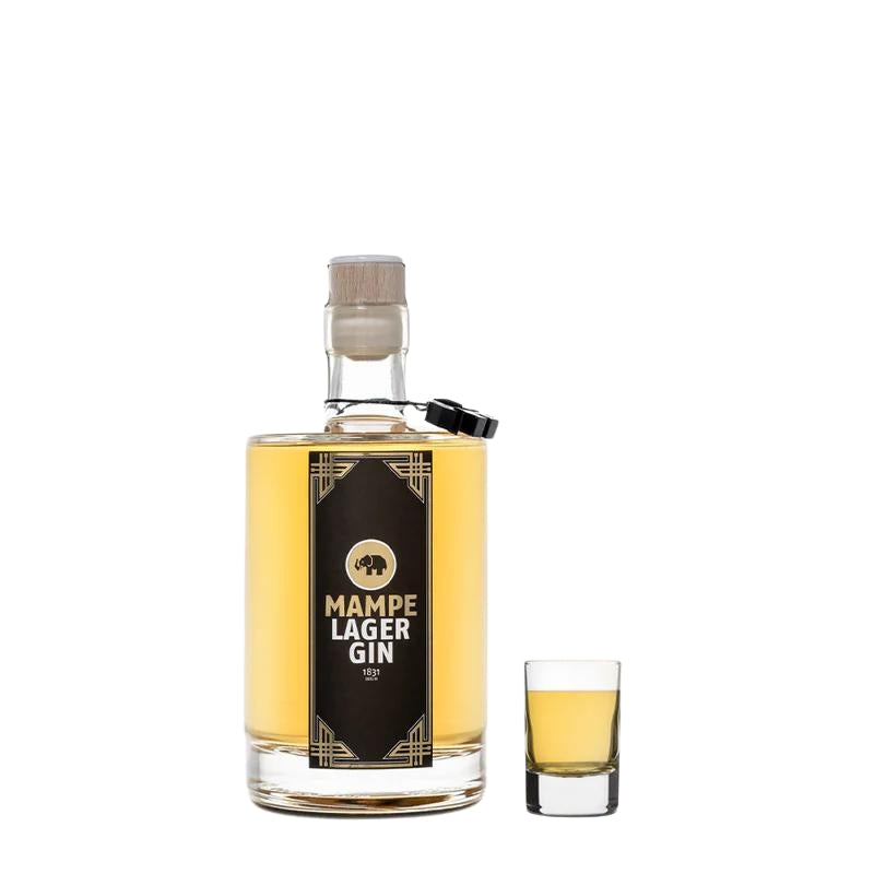 Mampe Lager Gin Galileo in der 0,5l Flasche mit einem kleinen gefüllten Shotglas daneben – ideal zum Servieren.