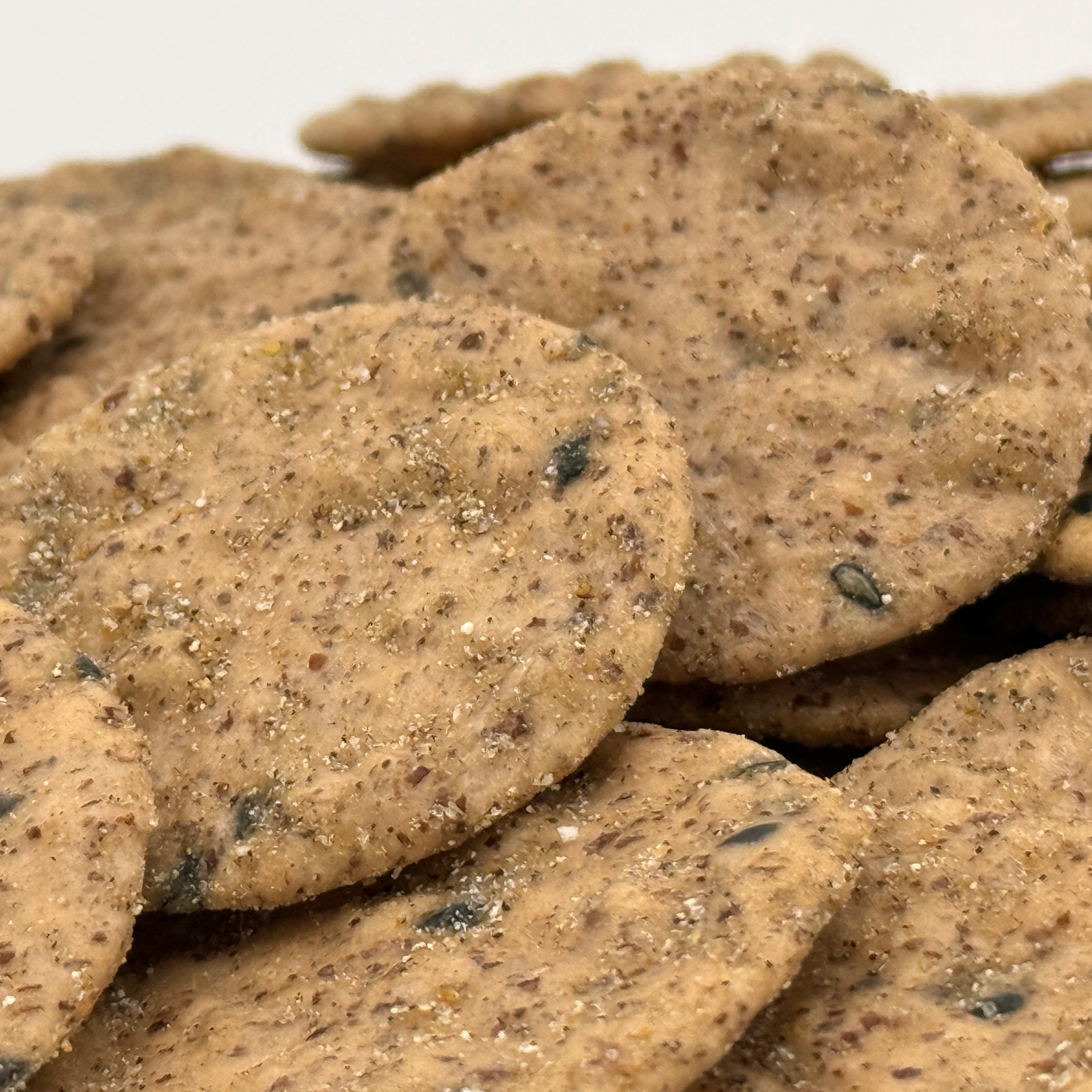 Nahaufnahme würziger Sesam-Pfeffer-Cracker mit sichtbaren Körnern – glutenfreie Alternative für Hotelgäste und Lounges.