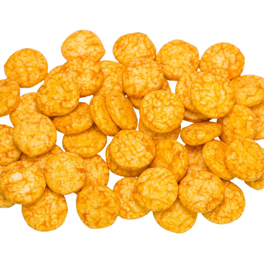Knusprige, rund gebackene Reissnacks mit orange-roter Chili-Würzung, gleichmäßig verteilt auf weißem Hintergrund.