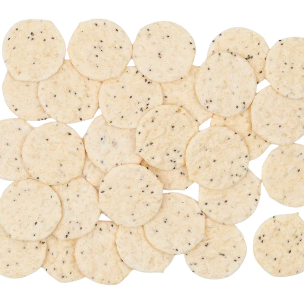 Helle, runde Reischips mit sichtbaren Chiasamen, gleichmäßig verteilt auf weißem Hintergrund – glutenfreie Cracker mit knuspriger Textur.