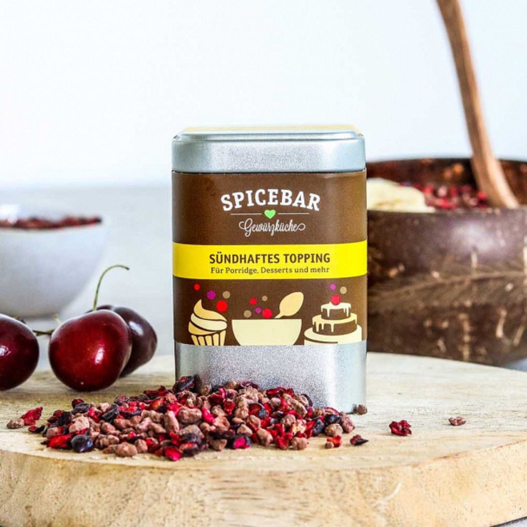 Sündhaftes Topping von Spicebar in Szene gesetzt mit frischen Kirschen und Porridge im Hintergrund – ideal als fruchtige Deko für Desserts.