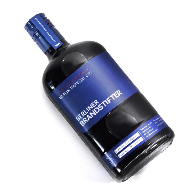 Liegend platzierte Flasche Berliner Brandstifter Dark Dry Gin mit dunkelblauer Gestaltung – Berliner Manufaktur-Spirituose.