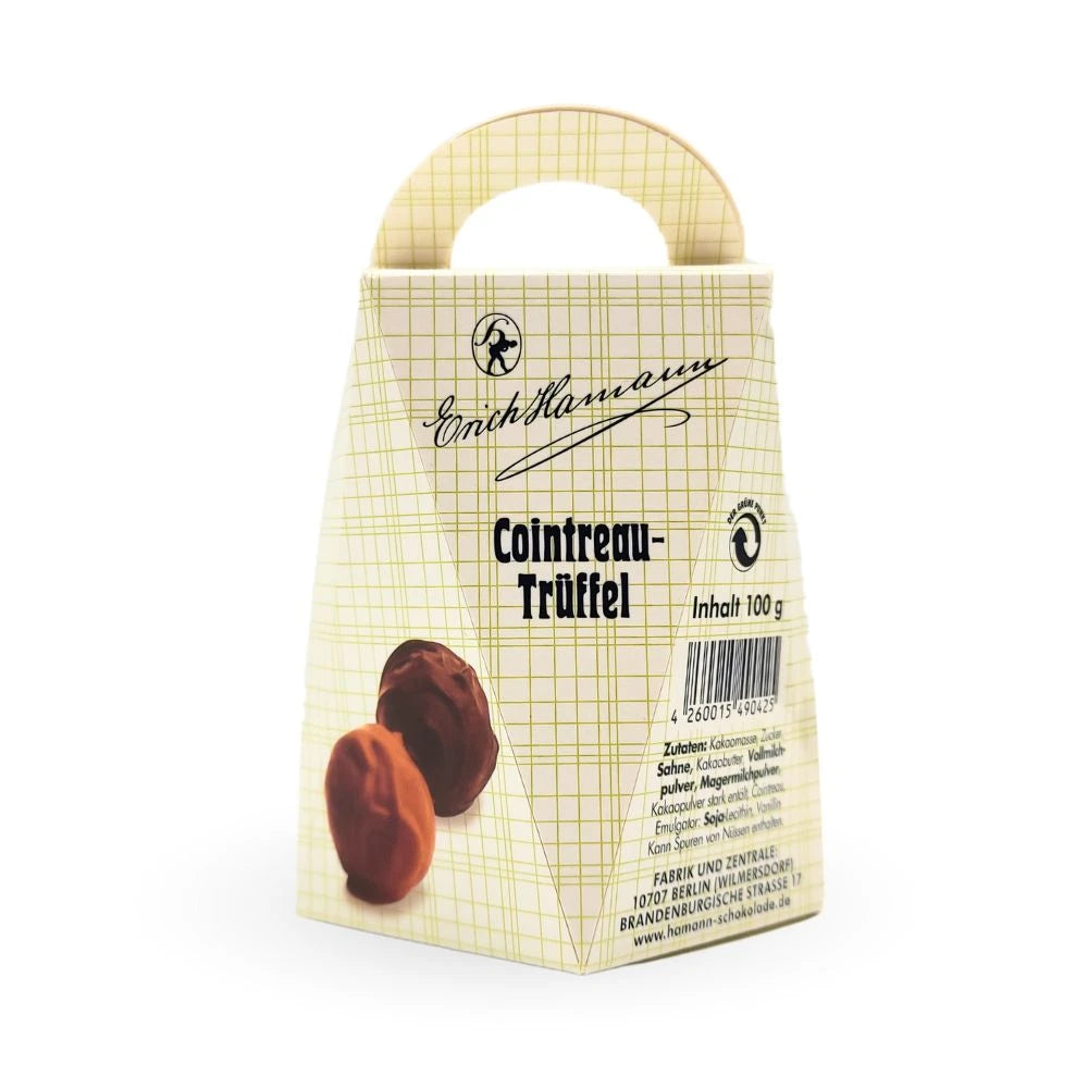 Verpackung der Erich Hamann Cointreau-Trüffel in hellgelber, kariert gestalteter Schachtel mit Tragegriff; elegante Aufschrift "Cointreau-Trüffel", darunter Abbildung zweier Pralinen.