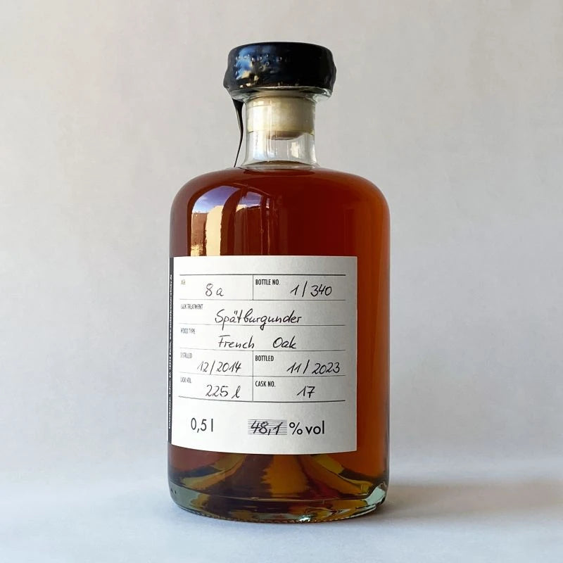Eschenbrenner Whiskyflasche „Joe“ mit handbeschriftetem Rücketikett. Zeigt Angaben zu Jahrgang, Fassart und Alkoholgehalt. Der Whisky hat eine tiefgoldene Bernsteinfarbe.