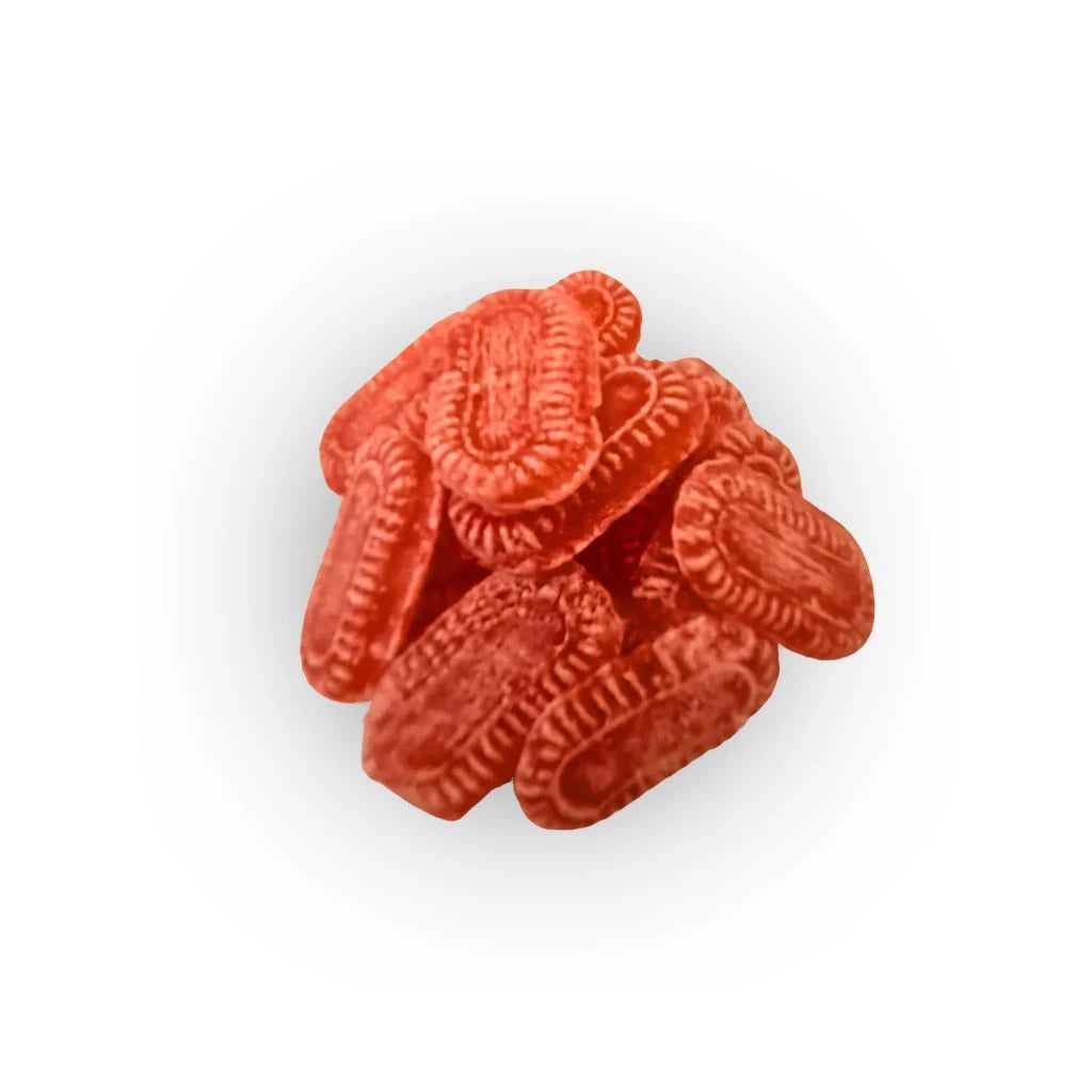 Mehrere rote Glühweinbonbons in ovaler Form mit geprägtem Muster auf weißem Hintergrund lose angeordnet.
