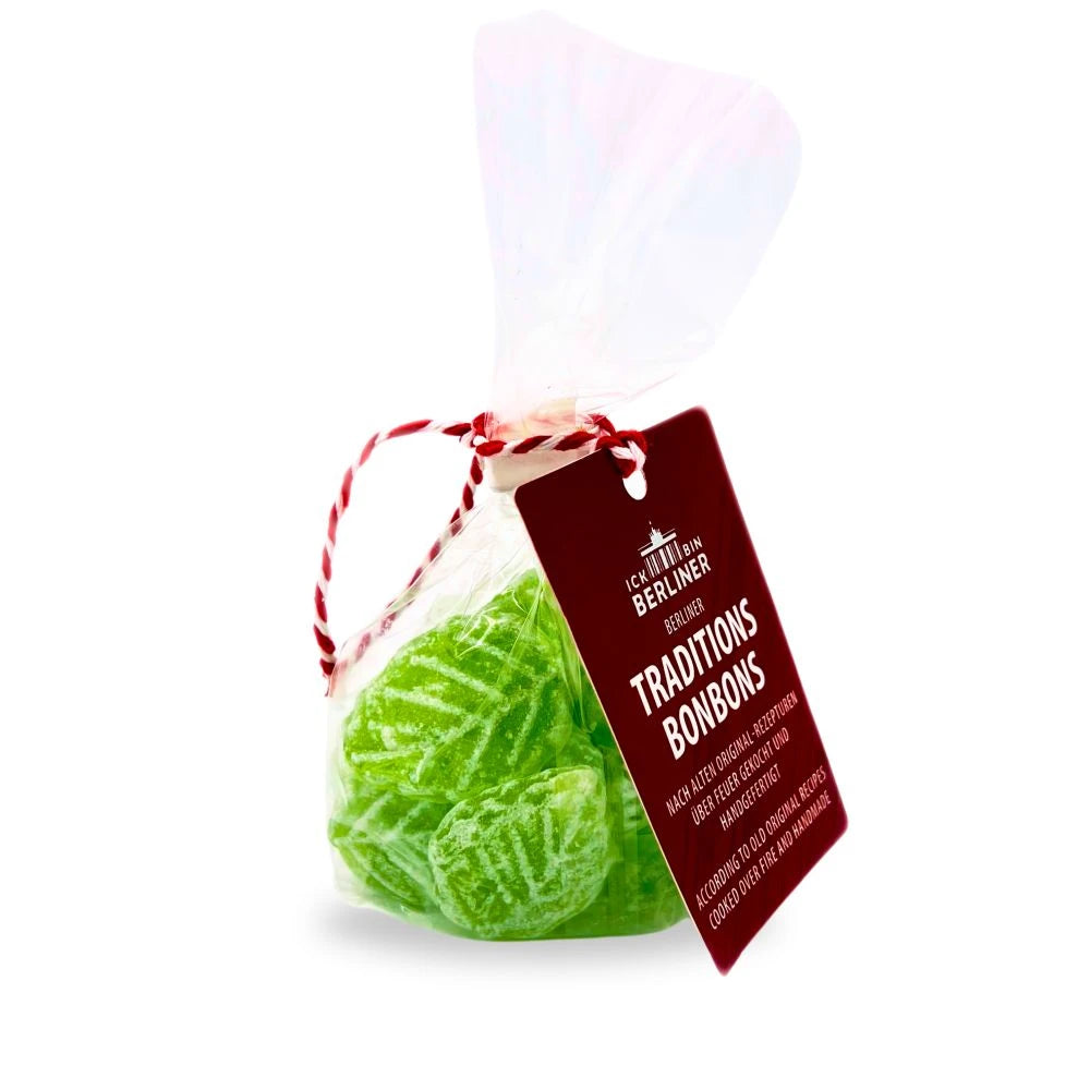 Grüne Bonbon-Tüte mit Etikett in Herzform, gebunden mit rot-weißer Kordel, traditionell verpackt und mit Waldmeistergeschmack.