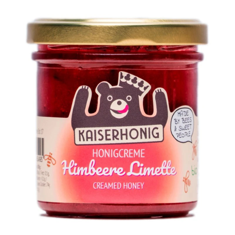 Glas Honigcreme der Sorte „Himbeere Limette“ von Kaiserhonig mit goldfarbenem Deckel, pinkem Etikett und dem typischen Bärenlogo, ergänzt um den Schriftzug „Made by bees & sweet people“.