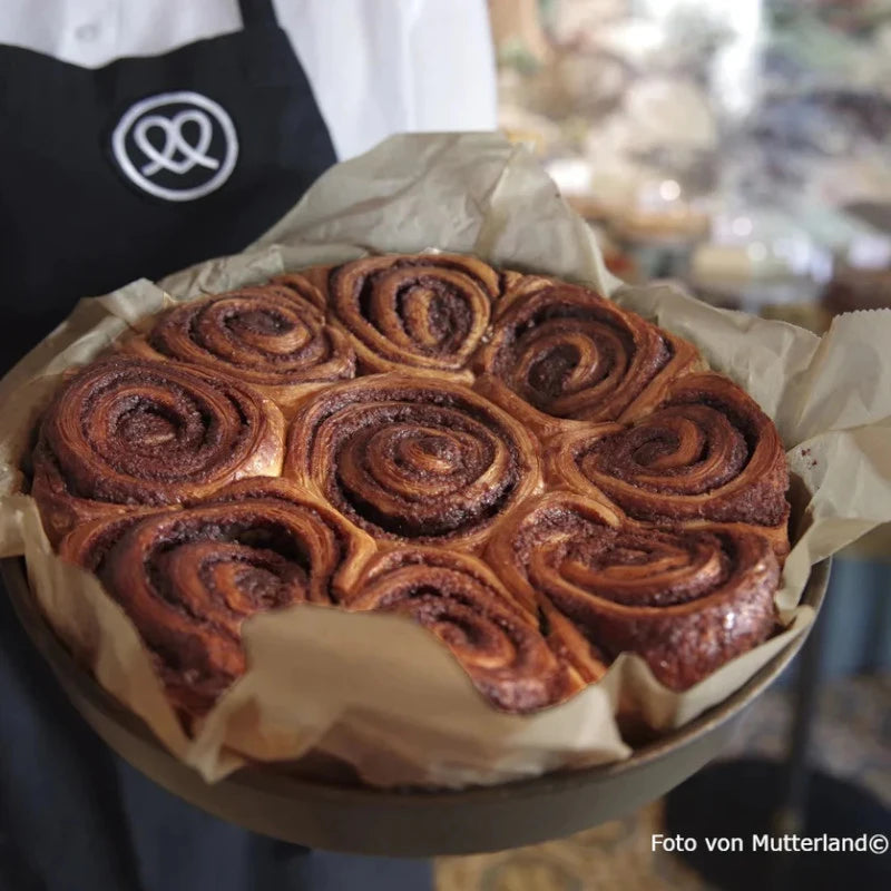 Ofenfrische Franzbrötchen in einer runden Backform – goldbraun gebacken mit Zimt-Zucker-Schichten. Inspiration für das Popcorn aus der Mutterland-Edition von Knalle.