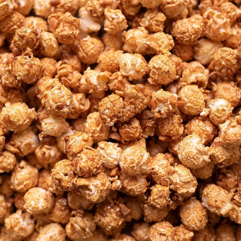 Detailansicht von karamellisiertem Popcorn mit knackigen Erdnussstücken – goldbraun gebacken und umhüllt von feinem Salzkaramell. Berliner Handwerkspopcorn mit cremig-nussiger Note.